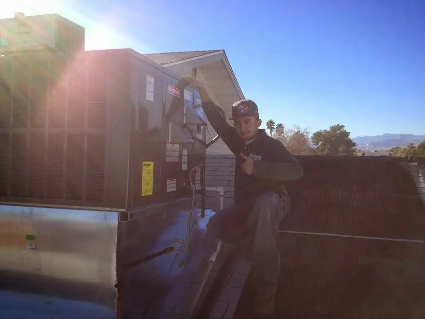 HVAC technician performing Heat Pump Repair on a rooftop unit in Lacey